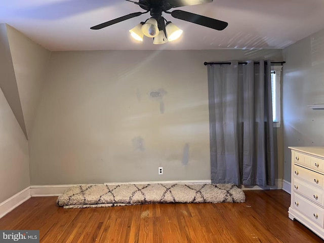 interior space featuring wood finished floors, baseboards, and a ceiling fan