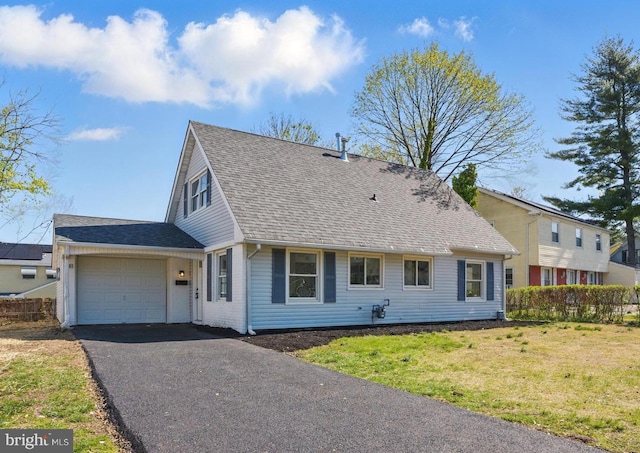 view of front facade with roof with shingles, a front yard, fence, an attached garage, and driveway