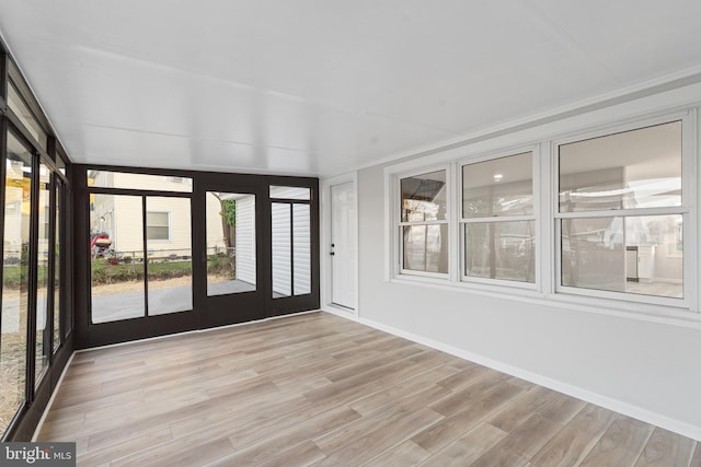 unfurnished sunroom featuring wood finished floors and baseboards