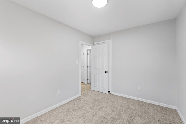 unfurnished bedroom featuring carpet flooring and baseboards