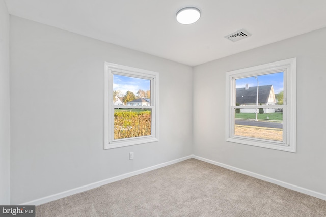 spare room featuring visible vents, baseboards, and carpet