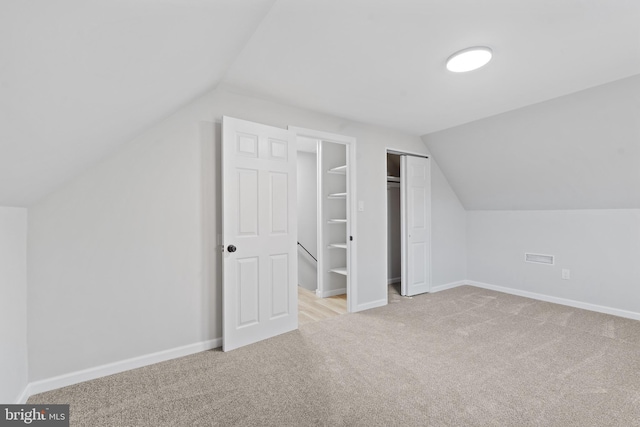 additional living space with baseboards, vaulted ceiling, and carpet floors