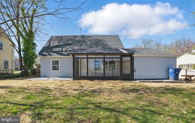 rear view of property featuring fence, a lawn, a patio area, a sunroom, and a shingled roof