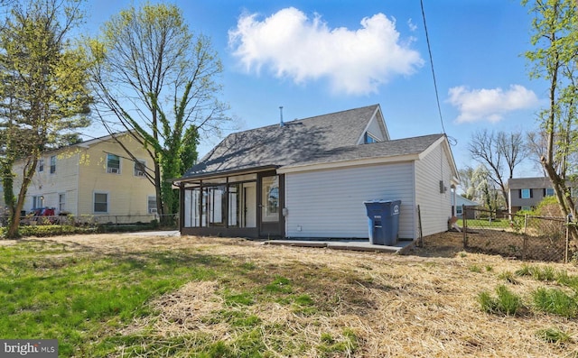 back of property featuring a sunroom and fence