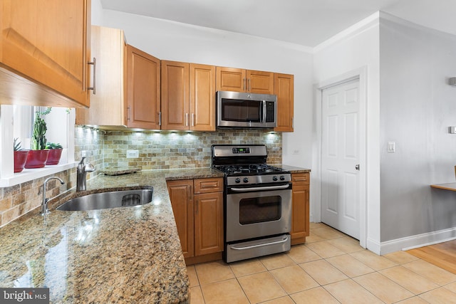 2513 Kimball St, Philadelphia, PA 19146 - kitchen featuring tasteful backsplash, light stone counters, brown cabinets, appliances with stainless steel finishes, and a sink