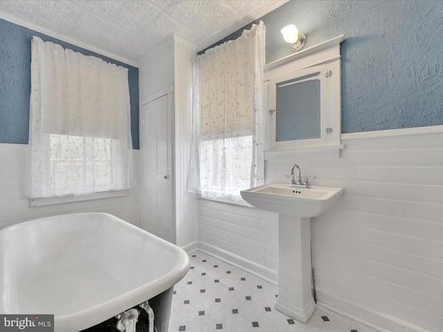 215 Biddle St, Gordon, PA 17936 - bathroom featuring tile patterned floors, a wainscoted wall, a freestanding tub, and a sink
