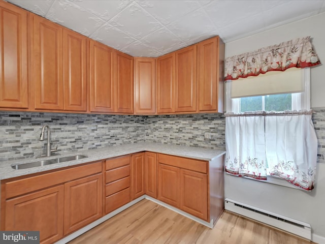 215 Biddle St, Gordon, PA 17936 - kitchen featuring a sink, light wood-style floors, decorative backsplash, baseboard heating, and light stone counters