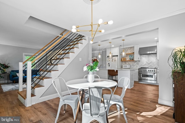 dining area with crown molding, stairs, and wood finished floors