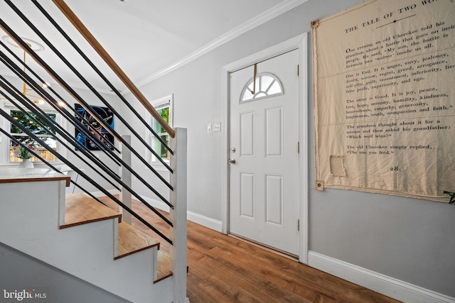 foyer entrance with crown molding, baseboards, stairs, and wood finished floors