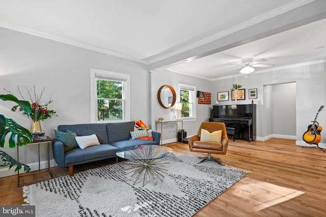 living area with baseboards, ornamental molding, wood finished floors, and a wealth of natural light