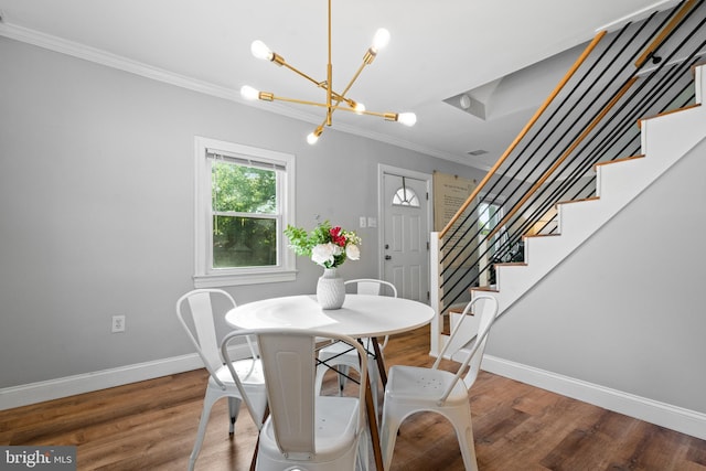 dining space with crown molding, wood finished floors, baseboards, a chandelier, and stairs