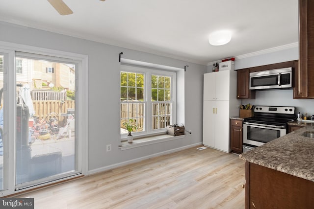 kitchen featuring dark brown cabinetry, stone countertops, stainless steel appliances, light wood-style flooring, and ornamental molding