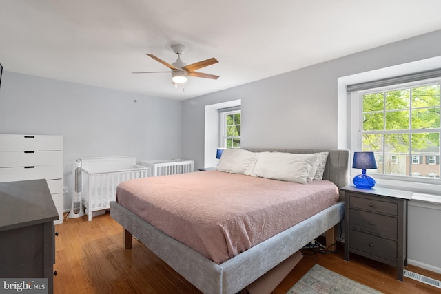 bedroom with visible vents, a ceiling fan, and wood finished floors