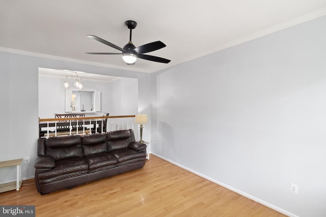 living room with wood finished floors, crown molding, baseboards, and ceiling fan