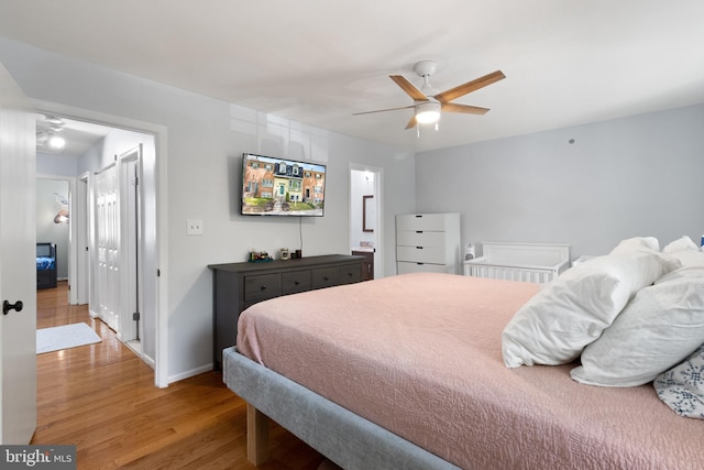 bedroom with ceiling fan, baseboards, wood finished floors, and ensuite bathroom