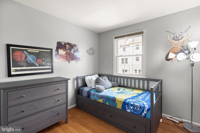 bedroom featuring baseboards and wood finished floors