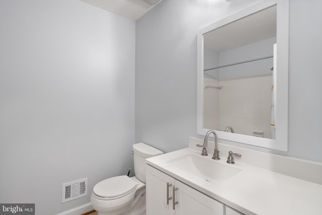 bathroom featuring toilet, baseboards, visible vents, walk in shower, and vanity