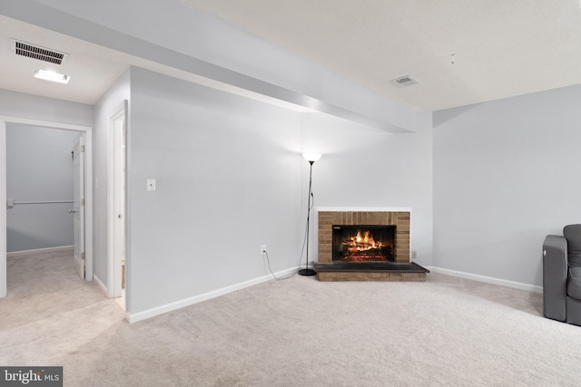 unfurnished living room with carpet flooring, visible vents, and a fireplace