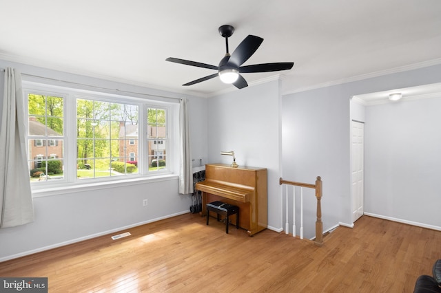 sitting room featuring wood finished floors, visible vents, ornamental molding, an upstairs landing, and baseboards
