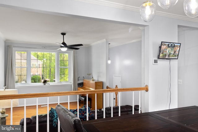 staircase featuring ceiling fan, ornamental molding, and wood finished floors