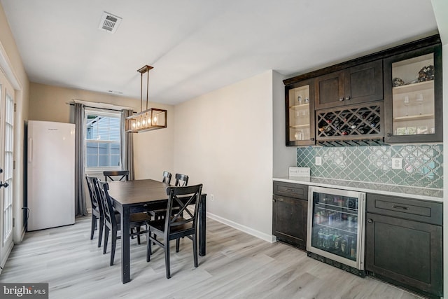 6022 Rixey Dr, Alexandria, VA 22303 - dining space featuring wine cooler, a dry bar, and light wood-style floors