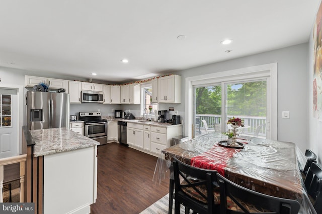 8412 Impalla Dr, Manassas, VA 20110 - kitchen featuring stainless steel appliances, a sink, white cabinetry, dark wood-style floors, and light stone counters