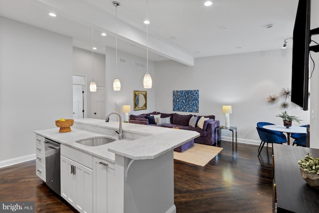 kitchen featuring a sink, baseboards, stainless steel dishwasher, hanging light fixtures, and open floor plan
