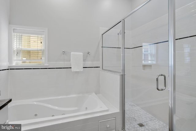 full bathroom featuring a whirlpool tub and a stall shower
