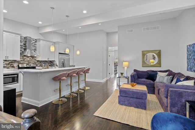 living room featuring baseboards, visible vents, dark wood-style flooring, and recessed lighting