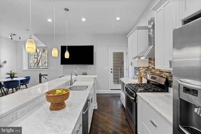 kitchen with tasteful backsplash, a sink, appliances with stainless steel finishes, dark wood-style floors, and wall chimney exhaust hood