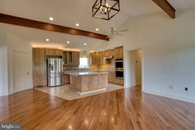 17634 Bruehl Rd, Upperco, MD 21155 - kitchen featuring stainless steel appliances, light wood-style floors, a kitchen island, under cabinet range hood, and decorative backsplash