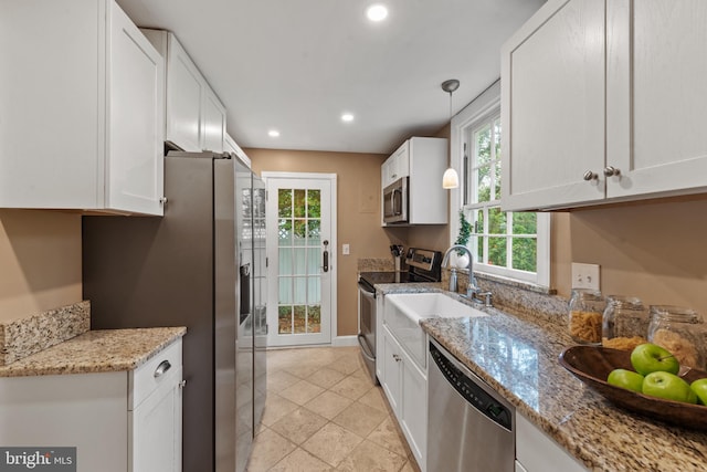 kitchen featuring stainless steel appliances, recessed lighting, white cabinetry, decorative light fixtures, and light stone countertops