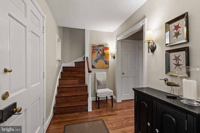 entryway with wood finished floors, stairs, and baseboards