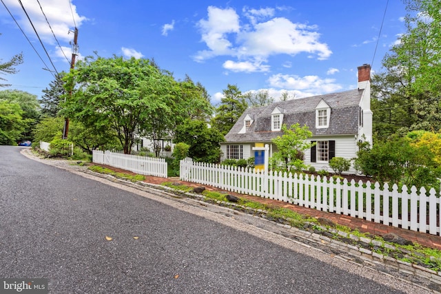 view of front facade with a chimney and a fenced front yard