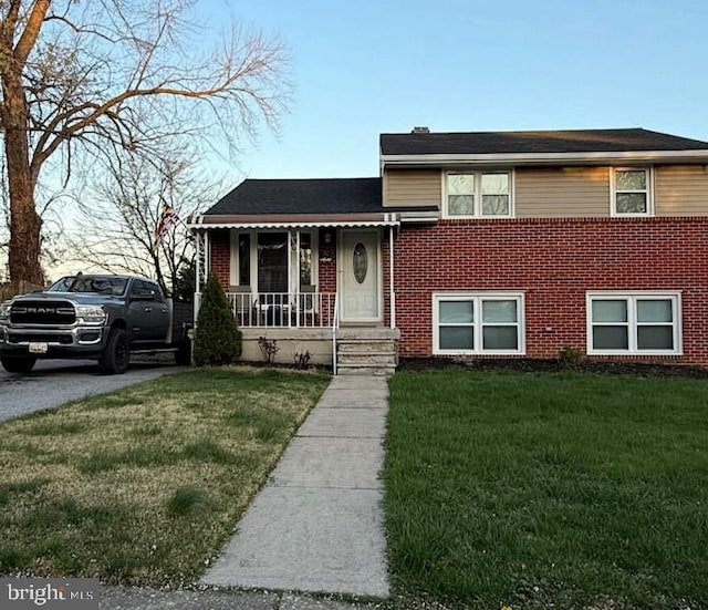 split level home featuring brick siding and a front yard