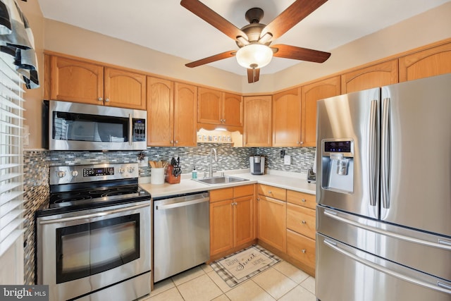 kitchen with a ceiling fan, tasteful backsplash, a sink, light countertops, and appliances with stainless steel finishes
