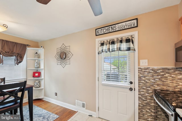 dining space with baseboards, wood finished floors, visible vents, and ceiling fan