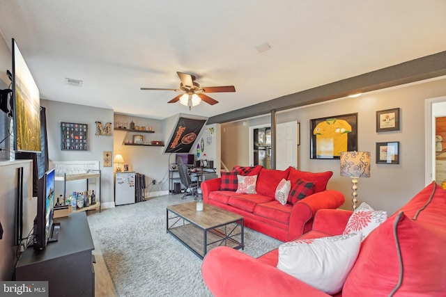 living room featuring baseboards, a ceiling fan, and visible vents
