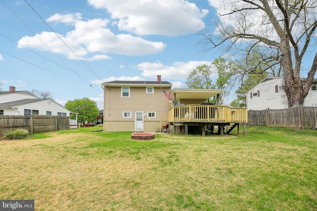 back of property featuring a wooden deck, a yard, a fenced backyard, and stairs