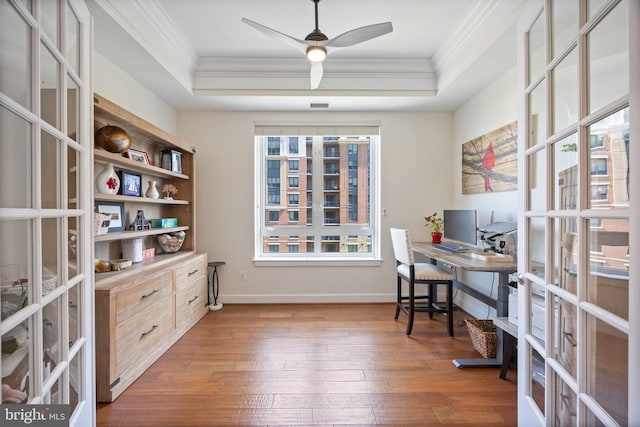 office area with ceiling fan, french doors, crown molding, hardwood / wood-style flooring, and a tray ceiling