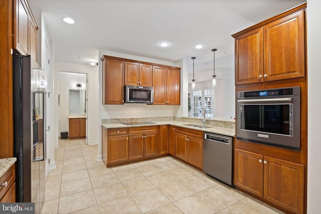 kitchen featuring light stone counters, a sink, brown cabinetry, stainless steel appliances, and light tile patterned floors