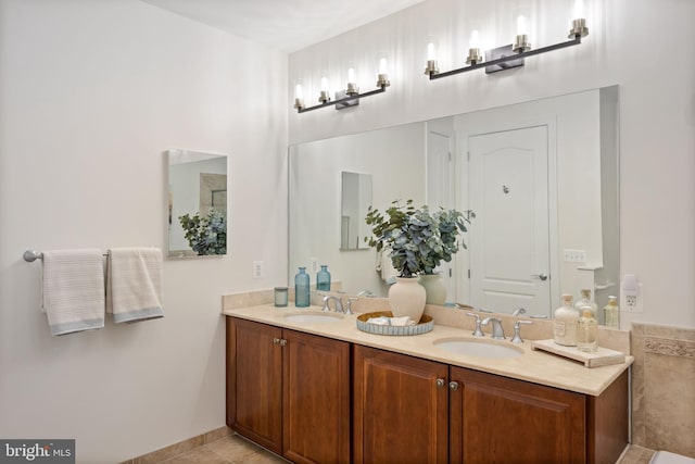 full bathroom featuring tile patterned flooring, a sink, baseboards, and double vanity