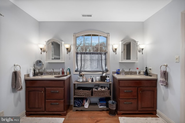 bathroom with two vanities, visible vents, and a sink