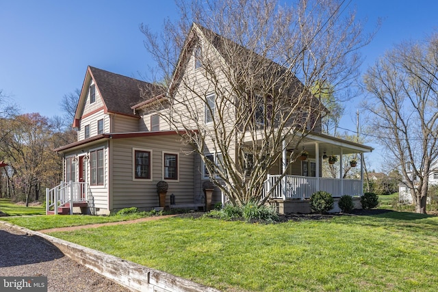 exterior space featuring a porch, a shingled roof, and a yard