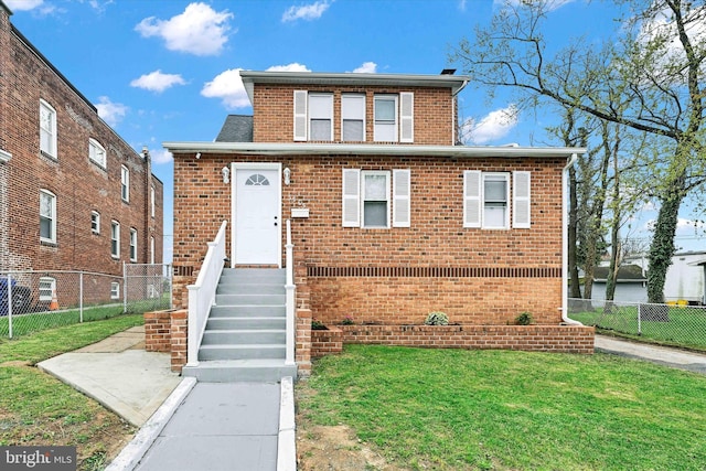 view of front of property featuring brick siding, a front lawn, fence, and a shingled roof