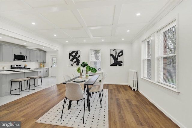 dining space featuring baseboards, recessed lighting, radiator, coffered ceiling, and wood finished floors