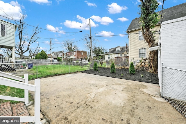 view of yard featuring a patio area, fence, and a residential view