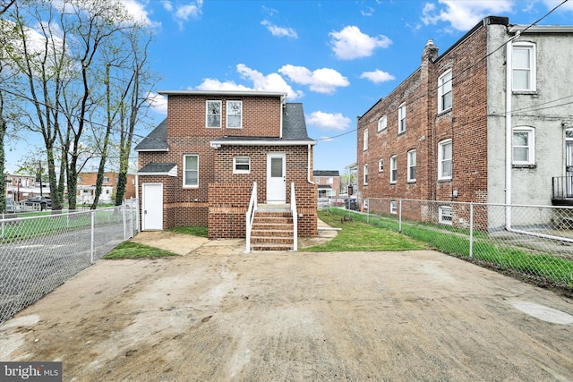 view of front of house featuring brick siding and fence