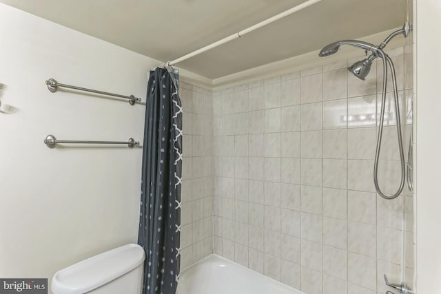 bathroom featuring shower / tub combo and toilet