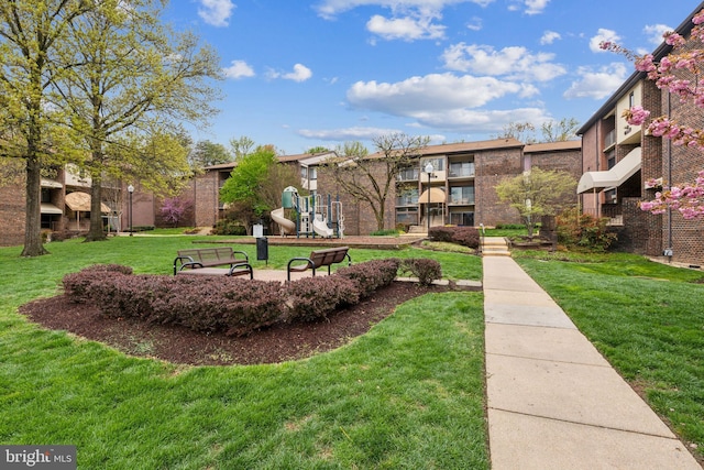 view of property's community featuring a yard and playground community